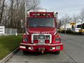 A red 1994 Freightliner FL80 fire truck with the words "FIRE DEPT" on the front bumper and several lights mounted on the roof
