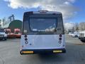 A white 2018 Chevrolet Express viewed from the rear with multiple lights and windows visible on the back panel