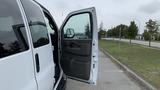 A 2017 Chevrolet Express Quigley 4x4 van with an open driver's side door showcasing the interior and seating area