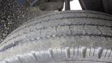 A close-up view of a worn tire with visible tread patterns and dirt on its surface