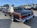 A brown 1982 Mercury Grand Marquis with a light tan vinyl roof showcasing classic styling and chrome accents