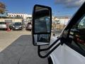 A side mirror of a 2015 Chevrolet Express reflecting the surroundings with a clear view of a parking lot and vehicles in the background