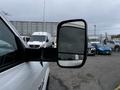 White 2018 RAM 3500 side mirror with a view of a cloudy sky and other vehicles in the distance