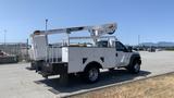 A 2011 Ford F-450 SD bucket truck with a Terex aerial lift mounted on the rear and service body compartments on the sides