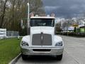 A 2014 Kenworth T370 truck facing forward with a shiny chrome grille and large side mirrors equipped with orange lights on top