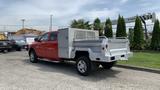 A red 2013 RAM 2500 pickup truck with a silver utility bed featuring a metal storage box and side railings