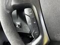Close-up of the steering wheel of a 2015 Chevrolet Express featuring control buttons for cruise control and audio functions
