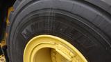 A close-up of a Michelin tire mounted on a yellow rim from a 2019 Caterpillar 972M XE heavy equipment machine