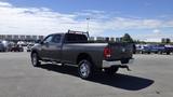 A 2014 RAM 3500 pickup truck with a grey exterior and chrome wheels parked in a lot with a visible bed rack and side steps