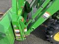 A green 2003 John Deere 790 tractor with a loader attachment and visible safety warning labels