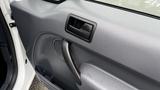 Interior door handle of a 2012 Ford Transit with a textured panel and speaker grill