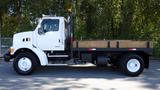 A 2007 Sterling Acterra L7500 truck with a flatbed in white color parked on a paved surface