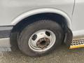 Close-up of a 2018 Chevrolet Express tire and wheel assembly showing a silver rim with visible lug nuts and a black tire with tread patterns