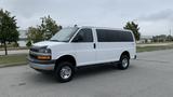 A 2017 Chevrolet Express Quigley 4x4 van with a white exterior and silver accents parked on a road