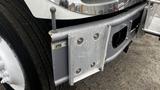 A 2006 International 7500 truck's front bumper with a metallic plate and mounting hardware visible