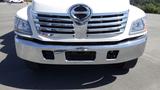 Front view of a white 2009 Hino 268 truck featuring chrome grille and bumper with empty license plate holder