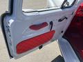 The image shows the interior door panel of a 1962 Ford F-100 featuring a white surface with a red quilted section and a door handle