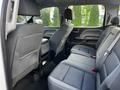 Interior view of the rear seating area of a 2017 GMC Sierra 1500 with two rows of comfortable fabric seats and a center console