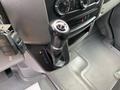 The gear shift of a 2017 Mercedes-Benz Sprinter with a black textured knob and surrounding control dials and panels