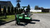 A green 2017 Laymor SweepMaster 300 with a large sweeping brush and operator's seat is parked on a paved surface