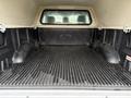 Interior of a 2018 Ford F-150 truck bed showing a lined surface with a Ford logo in the center and two wheel wells on either side