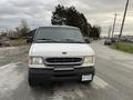 A 2001 Ford Econoline van with a white exterior parked on the side of a road