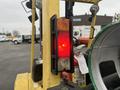 A red and orange rear light assembly mounted on a yellow forklift with a visible safety fire extinguisher beside it