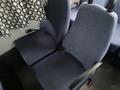 Two blue fabric seats with armrests and seat belts in a 2012 Chevrolet Express interior