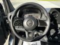 The steering wheel of a 2021 Mercedes-Benz Sprinter featuring the Mercedes emblem and controls for navigation and vehicle settings