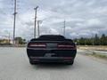 A black 2017 Dodge Challenger viewed from the rear showcasing its sleek design and signature taillights