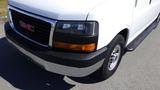 A white 2015 GMC Savana van with a black grille and orange turn signal light on the front passenger side