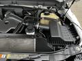 The engine compartment of a 2011 Ford F-250 SD showing the air intake system and other components with various hoses and containers