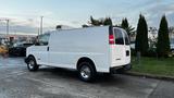 A white 2005 Chevrolet Express cargo van parked on a concrete surface with a smooth body and silver wheels