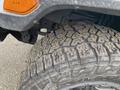 Close-up of a rugged tire from a 2020 Jeep Wrangler showing deep treads designed for off-road traction