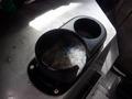A black plastic cup holder with two openings sits on a metallic surface