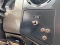 A close-up of a dashboard panel featuring a toggle switch labeled "TAILGATE RELEASE" alongside three metal screws