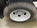 Close-up of a silver wheel and tire from a 2014 RAM 5500 with rugged tread and visible valve stem