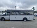 A 2017 Chevrolet Express shuttle bus with a gray exterior and numerous large windows on the side