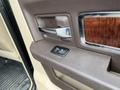 The interior door panel of a 2010 Dodge Ram featuring a textured brown surface chrome handle and a window control switch