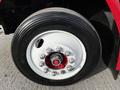 A close-up of a 1994 Freightliner FL80 tire featuring a polished chrome hub with multiple shiny lug nut covers and a black tire marked with the Michelin brand