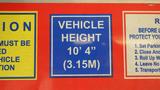 2006 Ford Econoline van prominently displaying a blue sign indicating a vehicle height of 10 feet 4 inches