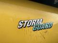 A yellow sticker on a machine displaying the text STORM GUARD in bold mixed font with scratches visible on the surface