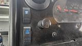 Dashboard controls of a 2006 Ford Econoline featuring buttons for mirror and defrost settings along with a rotary knob for additional functions