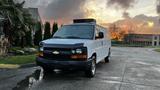 A white 2005 Chevrolet Express van is parked with a sleek front design and visible branding on the grille