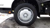 A close-up view of a 2016 Hino 195 truck wheel showcasing a silver rim and black tire with visible tread patterns