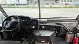 Interior dashboard of a 2006 Ford Econoline showing the steering wheel control panel and storage area