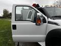 A 2014 Ford F-550 truck with an open driver's side door and a partially visible interior