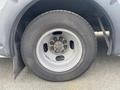 A close-up of a 2017 Chevrolet Express wheel showcasing the tire and alloy rim with visible lug nuts and a slightly worn tire tread