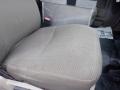 A driver's seat of a 2009 Ford F-450 SD with a light tan fabric cover showing some wear and a flat surface