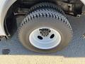 Close-up of a tire on a 2012 Ford Econoline showing a white rim and tread pattern on a black rubber tire